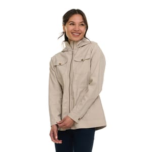 A woman is wearing a light beige jacket with a zip-up front and buttoned chest pockets. The jacket has a hood and is paired with dark jeans.