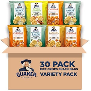 A variety pack of Quaker Rice Crisps in an open cardboard box displaying four different flavors: cheddar, caramel, apple cinnamon, and buttermilk ranch.