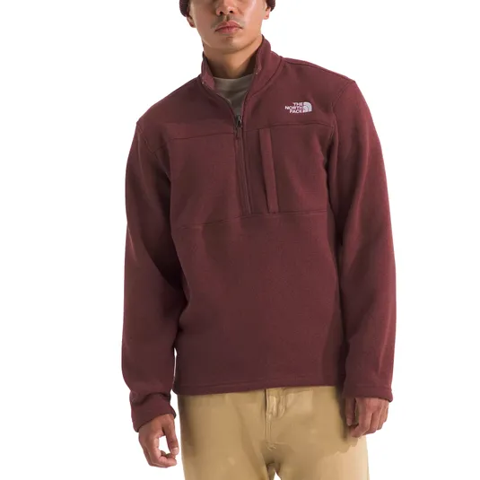 A person is wearing a maroon North Face quarter-zip fleece pullover with a chest pocket and light khaki pants.