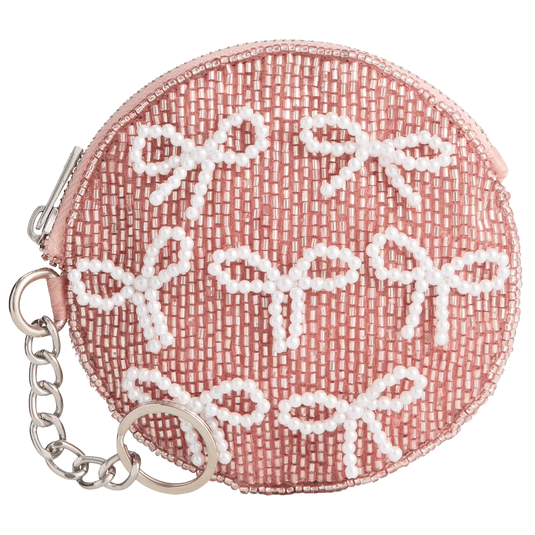 Round pink coin purse adorned with white beads shaped like bows, featuring a zipper closure and a metal keychain attachment.