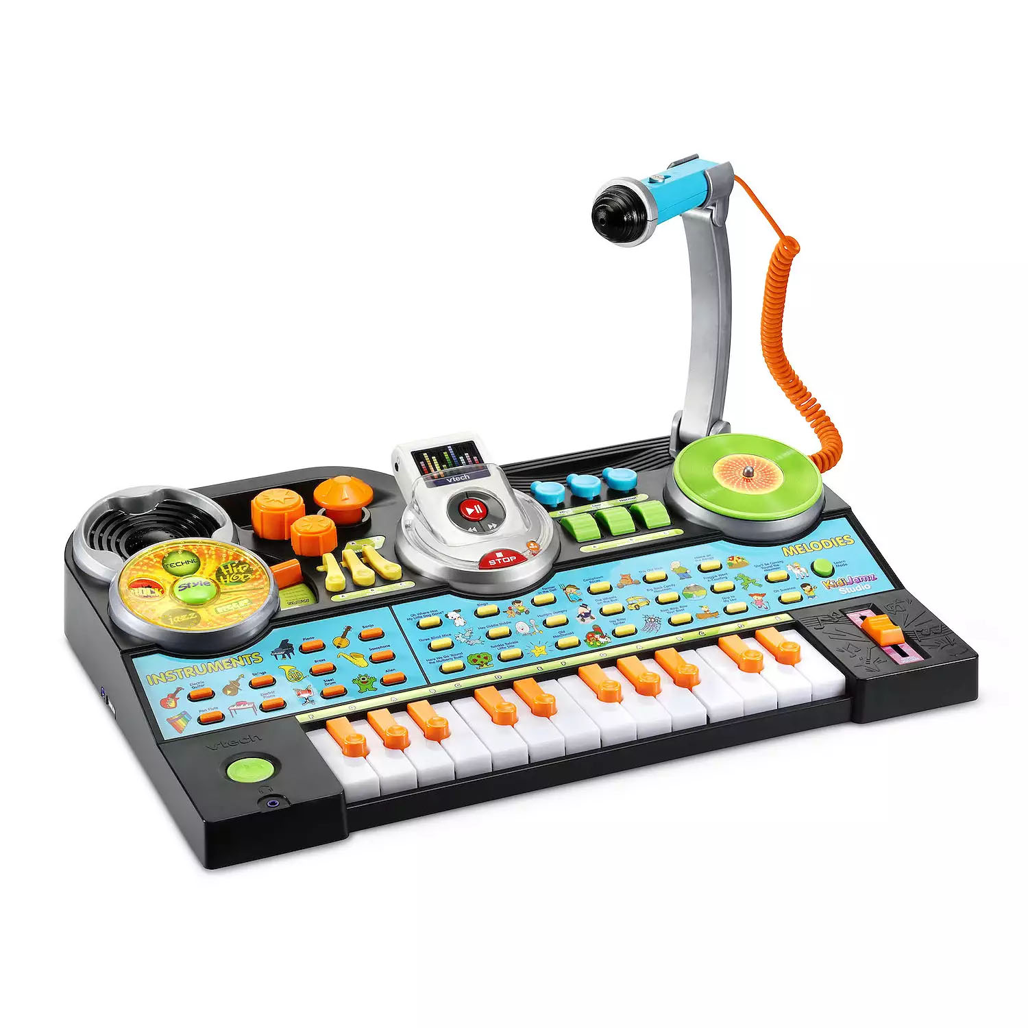 The V-Tech KidiJamz Studio is a colorful interactive music station for kids, featuring a keyboard, turntable, microphone, and various buttons and dials for sound effects and recording.