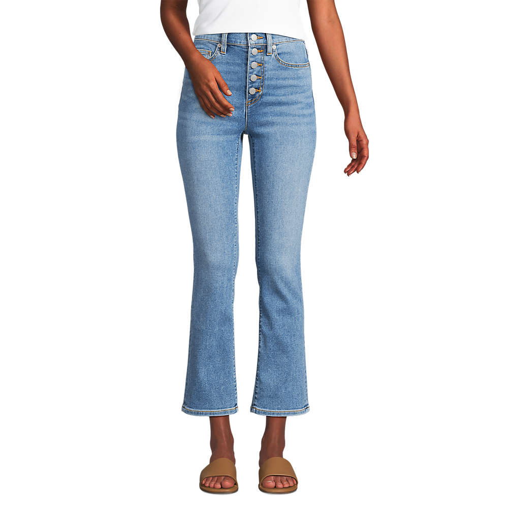 High-waisted light blue jeans with a button fly, flared legs, and brown slide sandals.