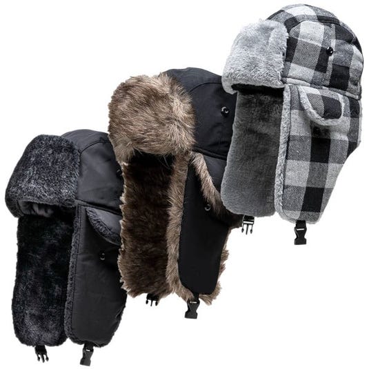 Three winter trapper hats are shown, each with ear flaps and faux fur lining. The designs include solid black, black with brown fur, and a black-and-white plaid pattern.