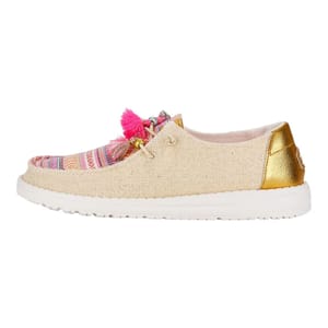 Casual espadrille-inspired shoe with a beige upper, gold-tone heel patch, and vibrant tassels.