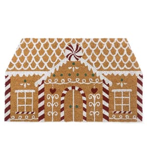A doormat designed to resemble a gingerbread house, featuring decorative white icing patterns and red stripes.
