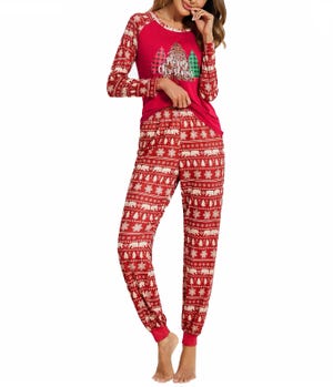 Red Christmas pajamas with a pattern of white holiday motifs and a long-sleeve top featuring a 'Merry Christmas' graphic with a tree.