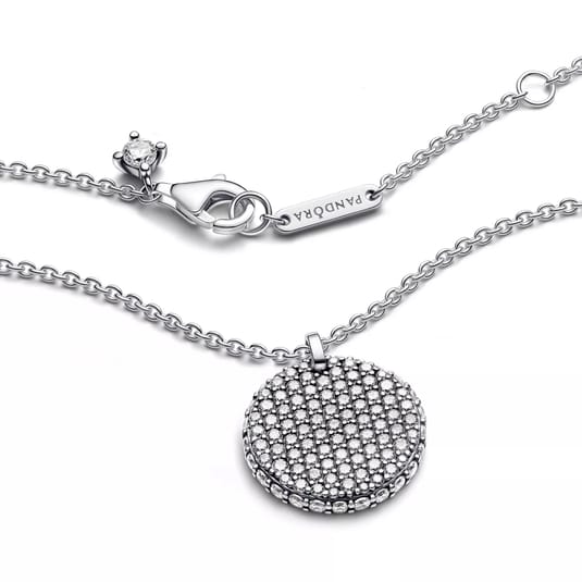 A silver Pandora necklace with a round, sparkling pendant and a branded tag near the clasp, featuring a lobster clasp closure.