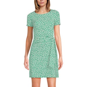 A green, short-sleeve, wrap-style mini dress with a white floral print. The dress features a round neckline and a waist tie.