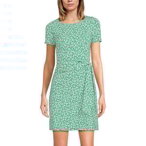 A green, short-sleeve, wrap-style mini dress with a white floral print. The dress features a round neckline and a waist tie.