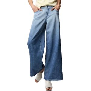 Wide-leg blue jeans with a gradient fade from light to dark, paired with white open-toed shoes.