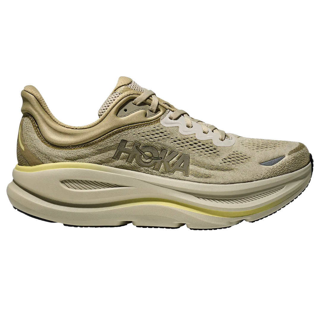 A beige Hoka running shoe with a thick, cushioned sole and mesh upper, featuring the Hoka logo on the side.