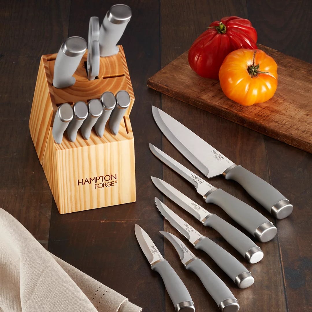 The Hampton Forge 15-piece cutlery set includes various knives with gray ergonomic handles and stainless steel blades, housed in a wooden block. The set features chef's, bread, utility, paring, and steak knives, alongside kitchen shears.