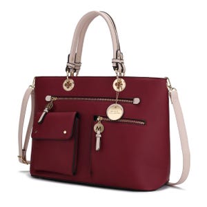 A burgundy handbag with beige handles and strap, featuring multiple exterior pockets, gold accents, and decorative charms.
