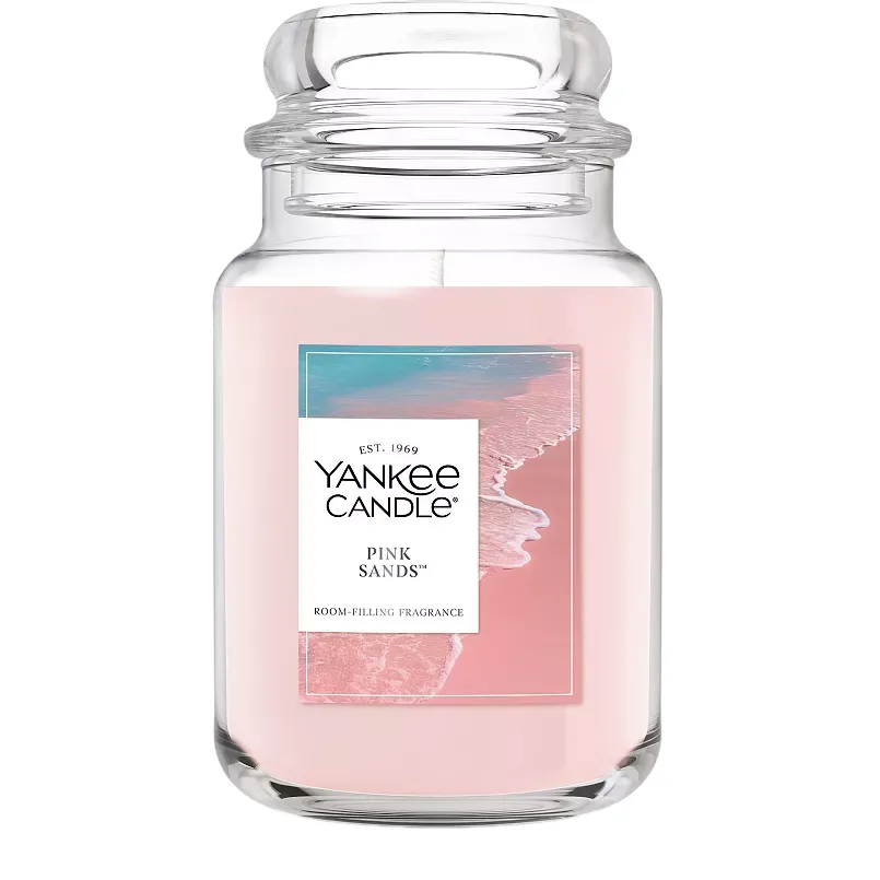 Yankee Candle \“Pink Sands\“ scented candle in a large glass jar with a pink hue, offering a room-filling fragrance.