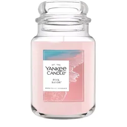 Yankee Candle \“Pink Sands\“ scented candle in a large glass jar with a pink hue, offering a room-filling fragrance.