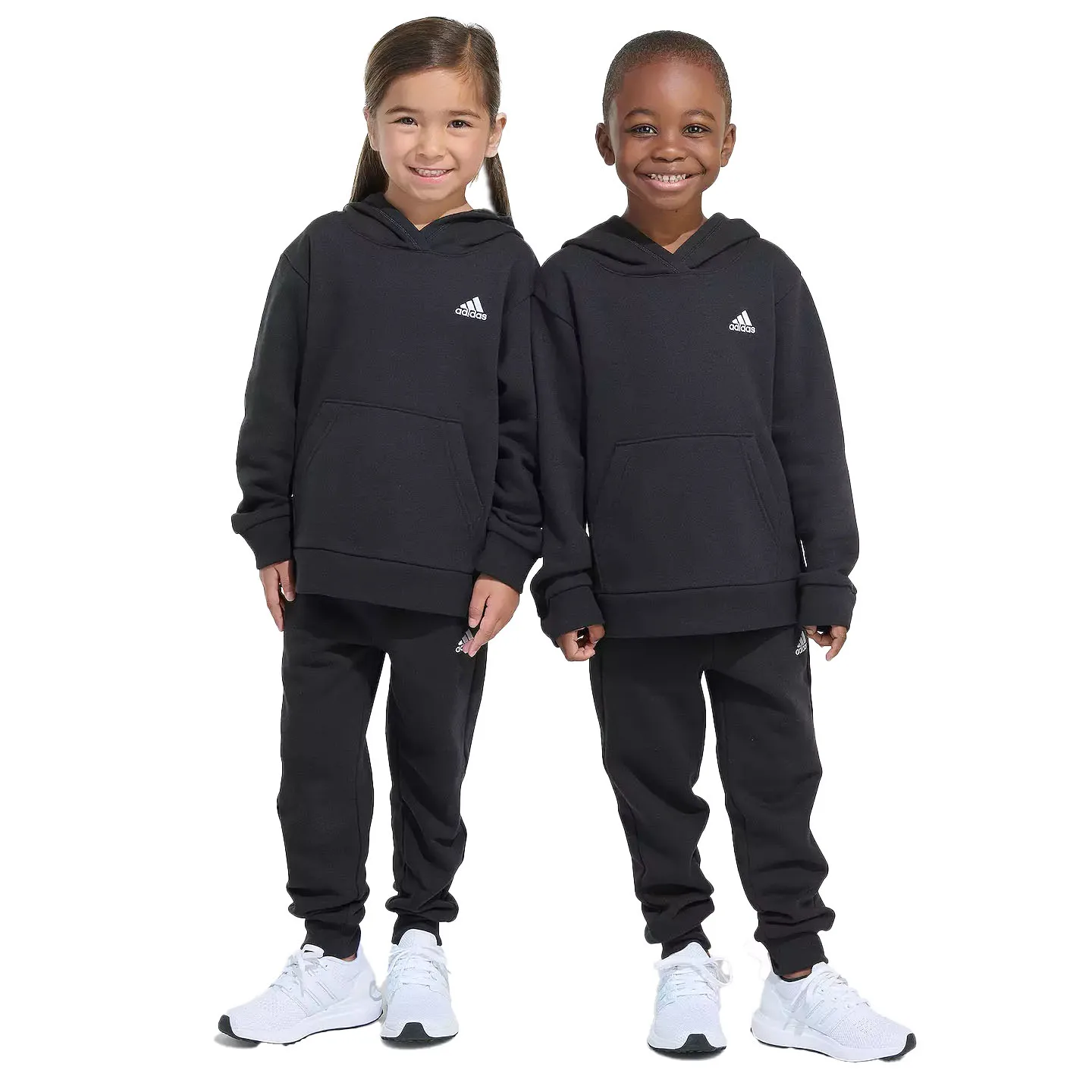 The Adidas Kids' Hoodie and Jogger Sets feature matching black hoodies and joggers with the Adidas logo on the chest and leg. The outfits are paired with white sneakers.