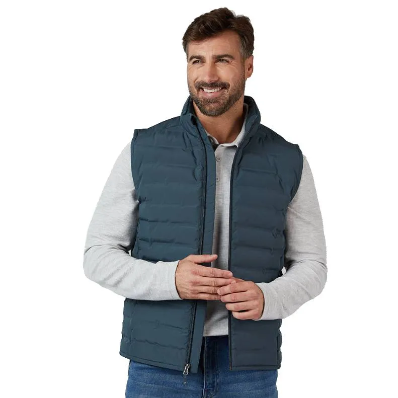 A man is wearing a dark blue padded vest over a light gray long-sleeve shirt and blue jeans.