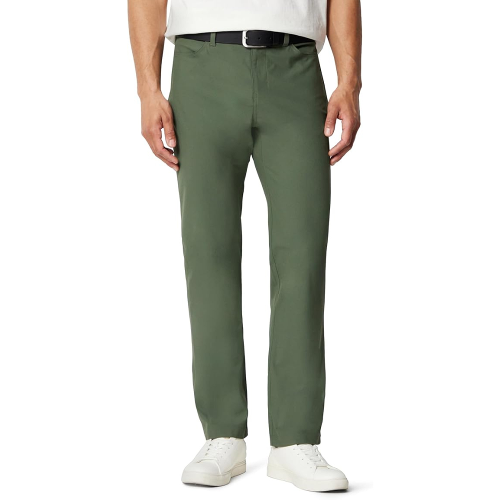 A man is wearing green chinos with a black belt and white sneakers, paired with a white shirt.