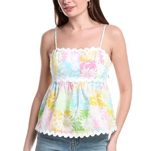 A sleeveless, multi-colored floral patterned top with spaghetti straps and a scalloped trim at the neckline and hem, paired with light blue jeans.