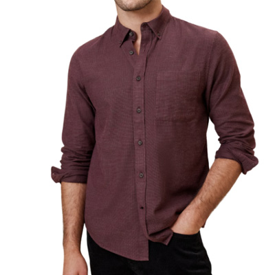 A person wearing a burgundy button-up shirt with rolled-up sleeves and a front pocket.