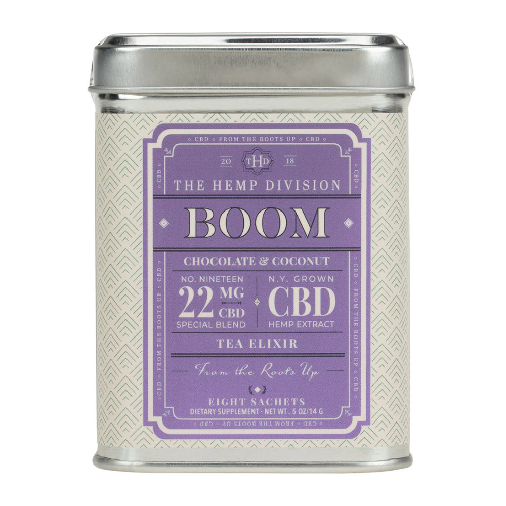The item is a tin of \“Boom\“ tea elixirs by The Hemp Division, featuring a chocolate and coconut flavor with 22 mg CBD per serving from N.Y. grown hemp extract, containing eight sachets.