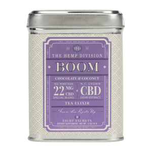 The item is a tin of \“Boom\“ tea elixirs by The Hemp Division, featuring a chocolate and coconut flavor with 22 mg CBD per serving from N.Y. grown hemp extract, containing eight sachets.