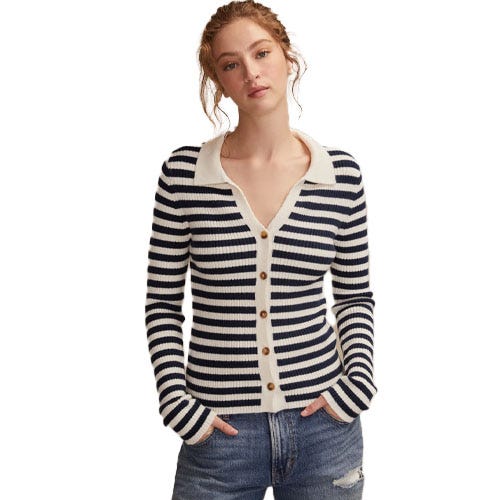 A woman is wearing a navy and white striped buttoned cardigan with a collar, paired with distressed blue jeans.