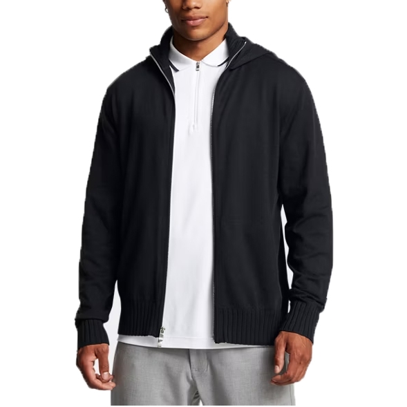 A person wears a black zip-up hoodie over a white polo shirt and light gray pants.