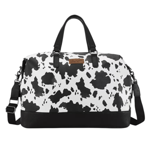 A black and white duffel bag with a cow print design, featuring black handles, a detachable shoulder strap, and a brown \“Wrangler\“ label on the front.