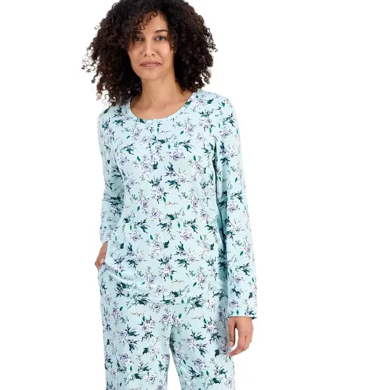 A woman is wearing light blue floral-patterned pajamas with long sleeves and matching pants.
