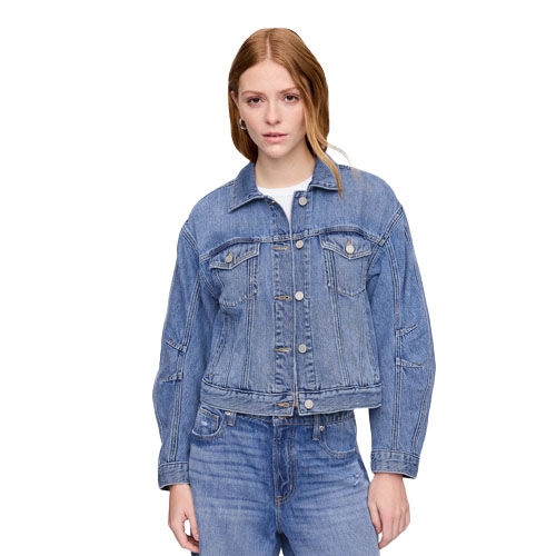 A woman is wearing a blue denim jacket over a white top, paired with blue jeans.