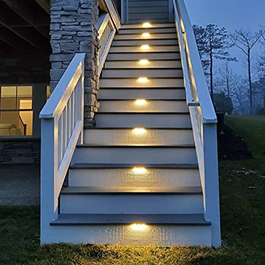 Outdoor staircase with step lights installed on the vertical risers, illuminating each tread.