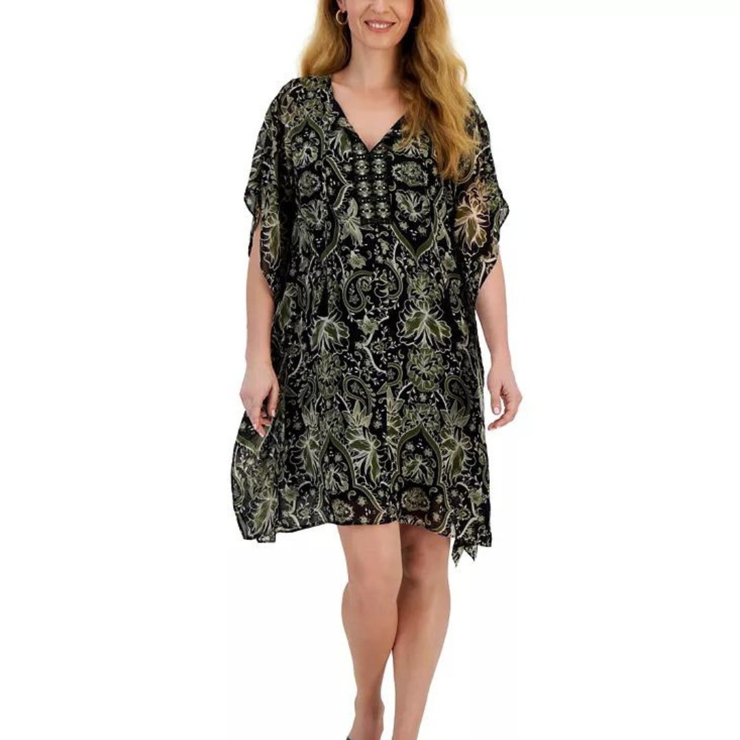 A woman is wearing a knee-length, patterned dress with a V-neck and flowing sleeves.