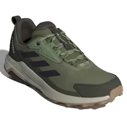 A green Adidas Terrex trail running shoe with black stripes, featuring a rugged design and durable grip for outdoor activities.