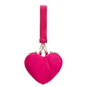 A bright pink, heart-shaped wristlet with dual zippered compartments, a gold clasp, and a detachable strap featuring the Lululemon logo.