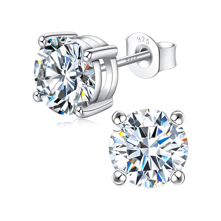 A pair of round cut, sparkling stud earrings set in silver with four prongs securing the stones. The backing is stamped with \“925,\“ indicating sterling silver.