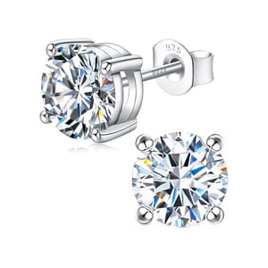 A pair of round cut, sparkling stud earrings set in silver with four prongs securing the stones. The backing is stamped with \“925,\“ indicating sterling silver.