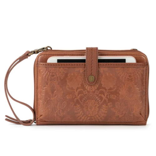 Brown leather wristlet wallet with embossed floral design, featuring a strap and a snap closure, partially open showing a mobile device inside.