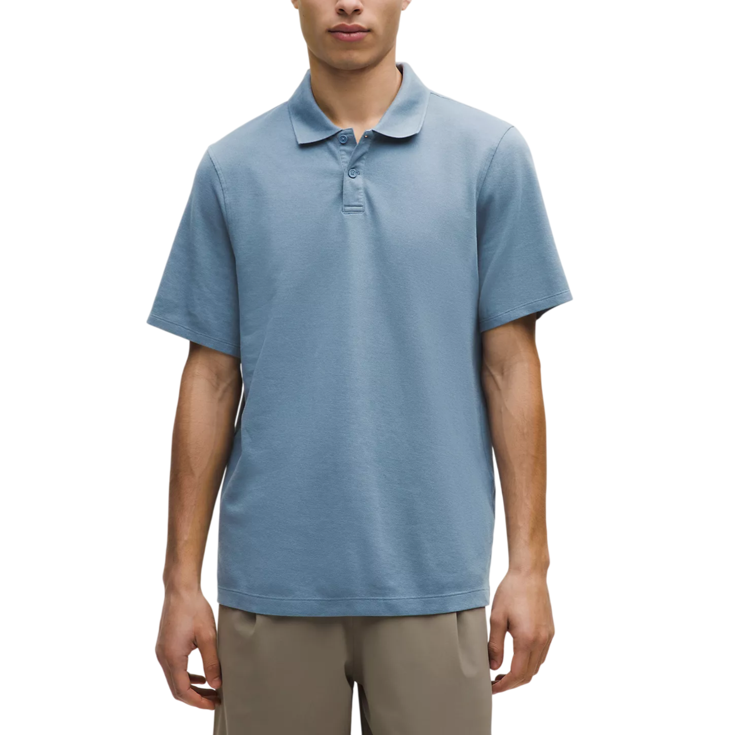 A man is wearing a light blue short-sleeve polo shirt paired with beige trousers. The shirt features a classic collar and button details.