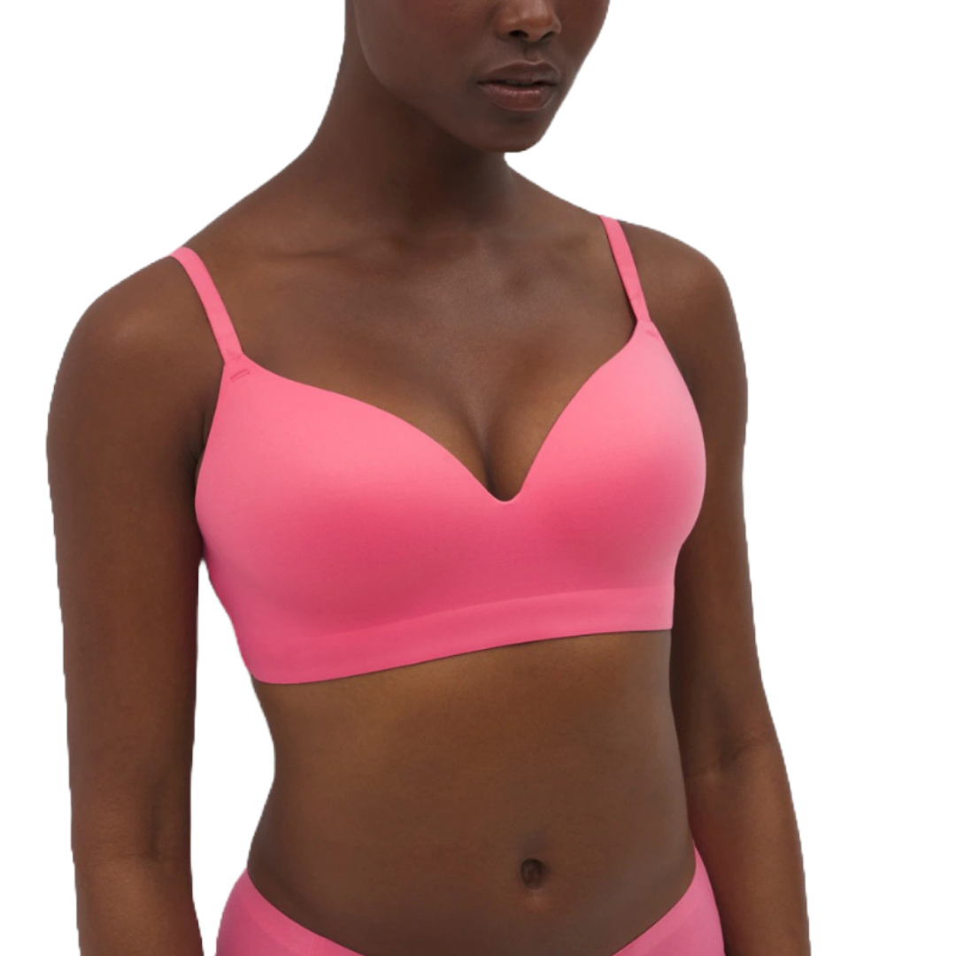 A pink, seamless, wireless, V-neck bra with adjustable straps, offering a smooth and comfortable fit.