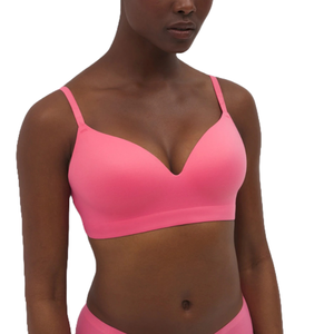 A pink, seamless, wireless, V-neck bra with adjustable straps, offering a smooth and comfortable fit.