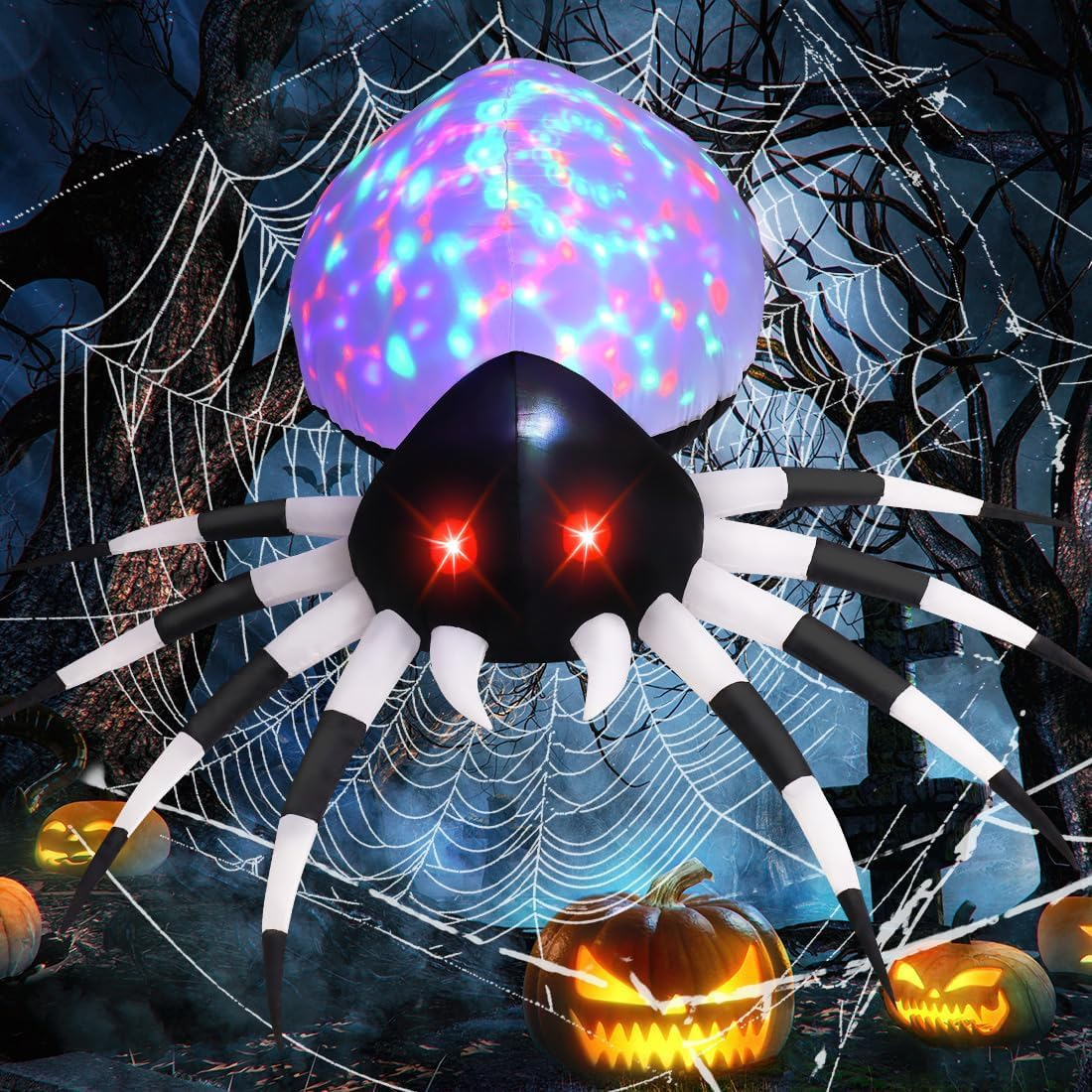 A large inflatable spider with red glowing eyes and a colorful, illuminated abdomen is displayed among spiderwebs and jack-o'-lanterns.