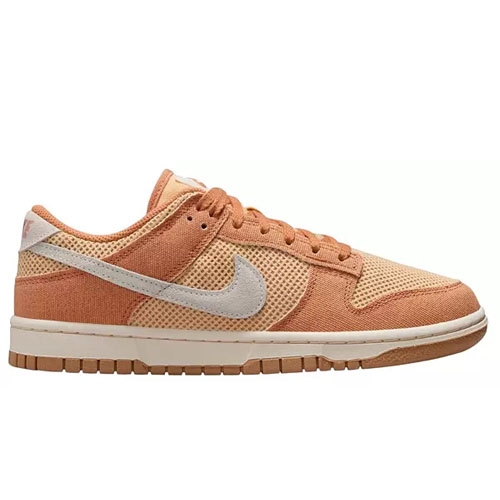 A Nike Dunk Low sneaker in shades of peach and orange with a light gray swoosh, featuring a textured design and a rubber sole.