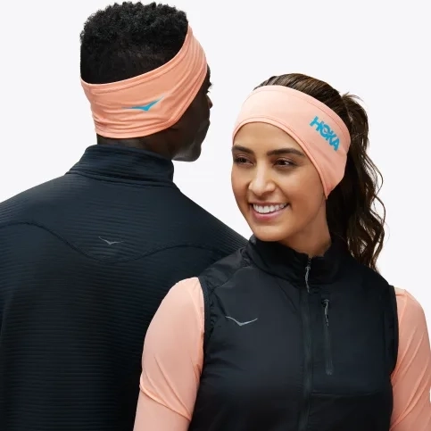 A man and woman wearing sports headbands, with the woman in a sleeveless vest and the man in a long-sleeve top.