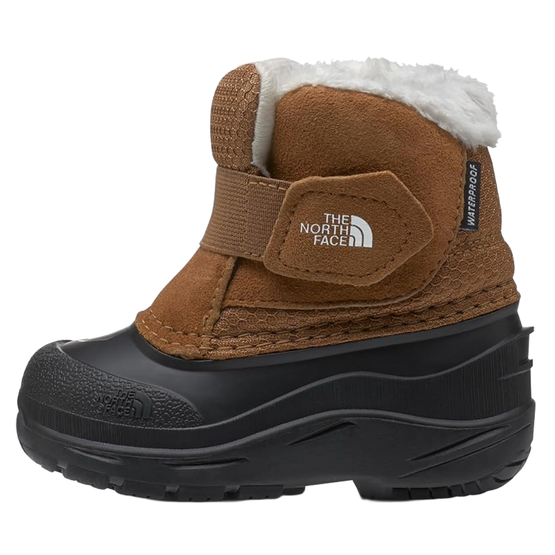 The photo shows a brown and black waterproof boot by The North Face, featuring a fluffy white lining, Velcro strap, and textured sole.