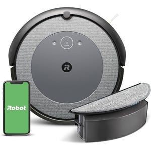 A round robot vacuum cleaner with a gray top and iRobot branding, shown with a smartphone displaying the iRobot app and an attachable cleaning accessory.