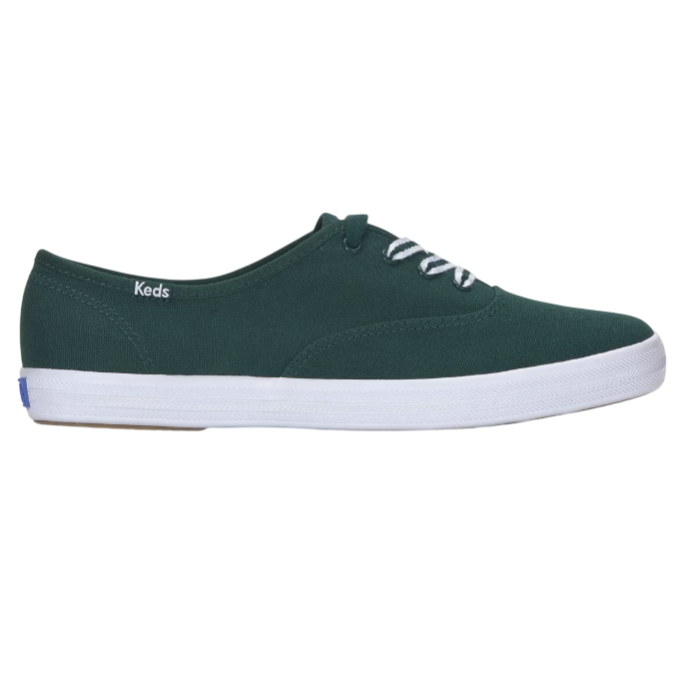 A dark green canvas sneaker with white laces and a white rubber sole, featuring the Keds logo on the side.