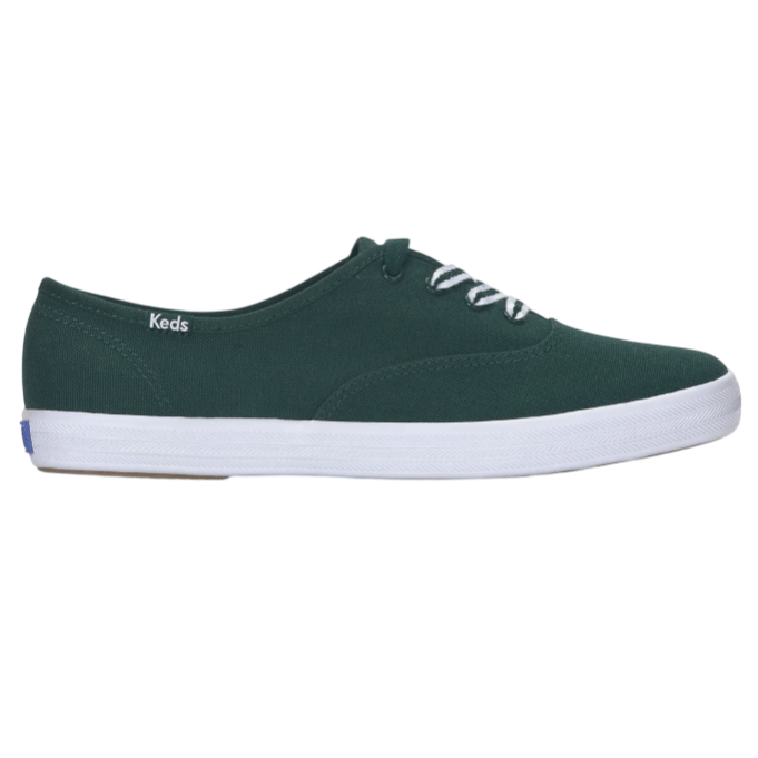 A dark green canvas sneaker with white laces and a white rubber sole, featuring the Keds logo on the side.