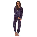 A woman is wearing a navy blue pajama set with colorful star patterns, featuring long sleeves and cuffed pants.