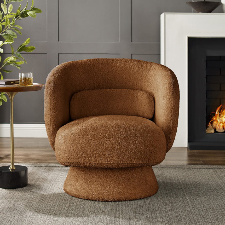 A brown, textured swivel chair is set beside a round side table with a brass stem, near a modern gray fireplace. A green potted plant accentuates the cozy room decor.